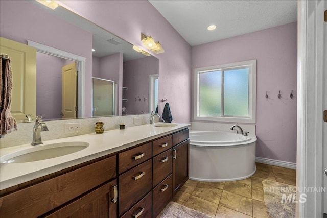 full bathroom with a sink, double vanity, a garden tub, and a stall shower
