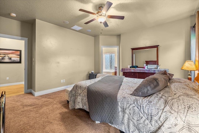bedroom featuring a textured ceiling, visible vents, ceiling fan, carpet flooring, and baseboards