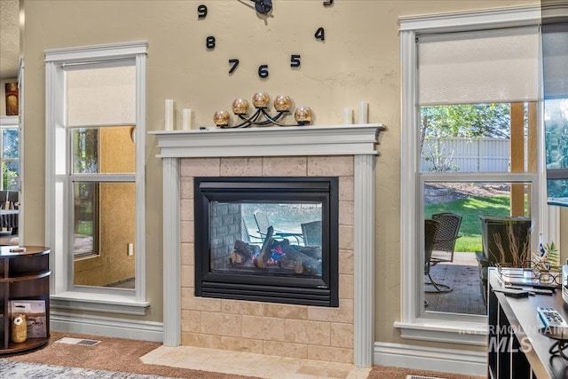 room details featuring carpet flooring, baseboards, visible vents, and a tile fireplace