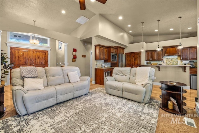 living area featuring visible vents, ceiling fan, and recessed lighting