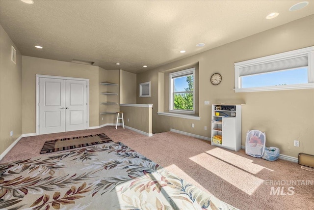 carpeted bedroom featuring a textured ceiling, visible vents, baseboards, and recessed lighting