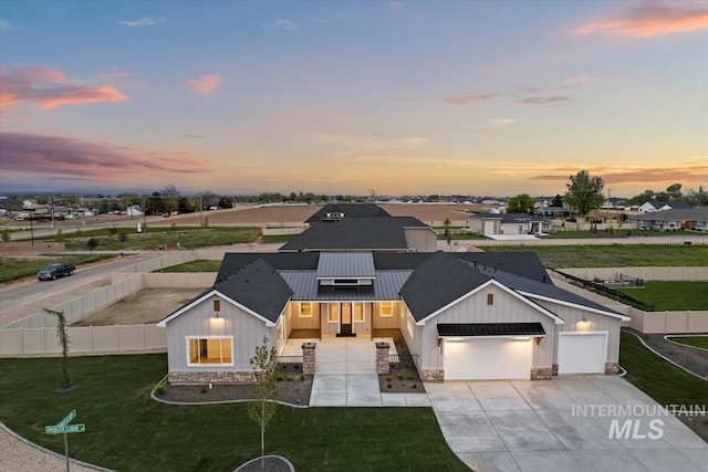 view of front of house featuring a garage and a lawn