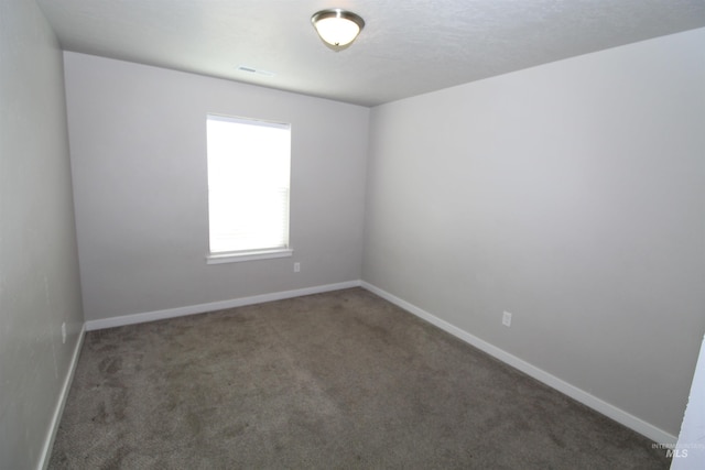 carpeted spare room featuring visible vents and baseboards