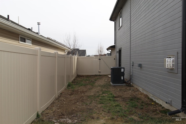 view of yard with cooling unit, a gate, and fence