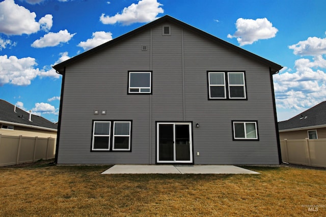 rear view of house with a patio area, a fenced backyard, and a lawn