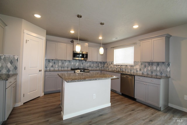 kitchen featuring stone counters, appliances with stainless steel finishes, dark wood-type flooring, and gray cabinetry