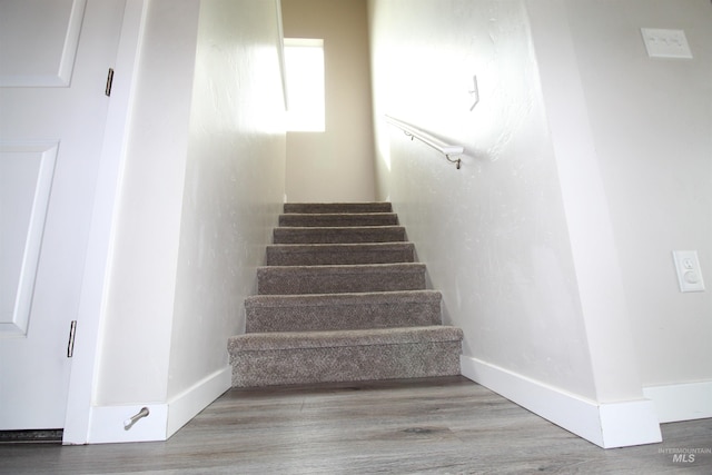 stairs featuring baseboards and wood finished floors