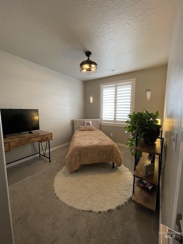 bedroom featuring a textured ceiling and carpet