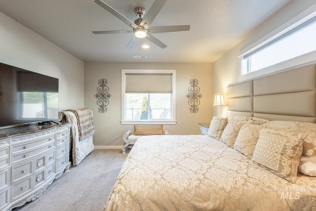 carpeted bedroom with ceiling fan and multiple windows