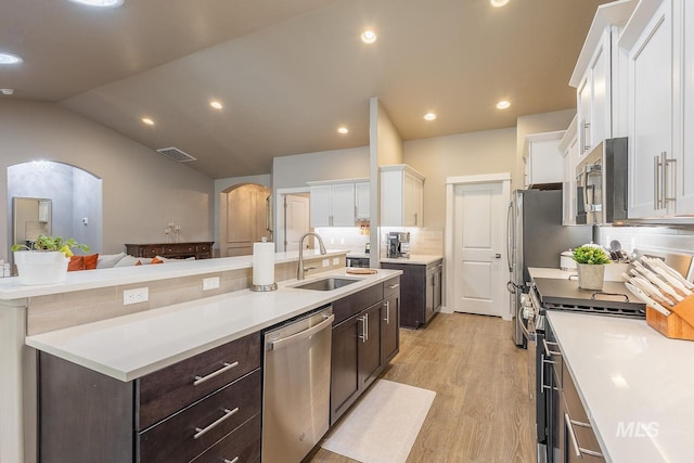 kitchen with appliances with stainless steel finishes, white cabinetry, sink, light hardwood / wood-style flooring, and dark brown cabinets