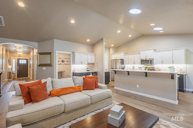 living room with lofted ceiling and light wood-type flooring