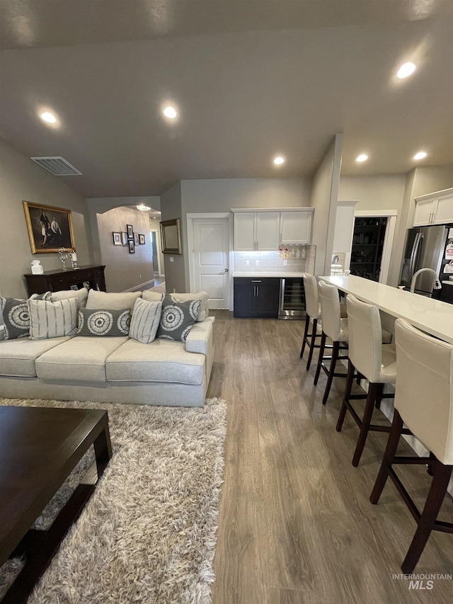 living room with wine cooler and wood-type flooring