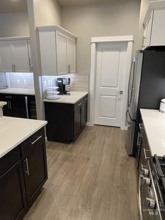 kitchen with white cabinets, range, and tasteful backsplash