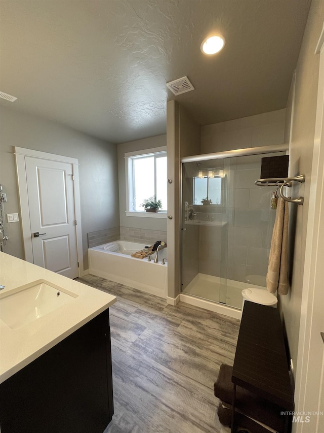 bathroom with vanity, independent shower and bath, and hardwood / wood-style flooring