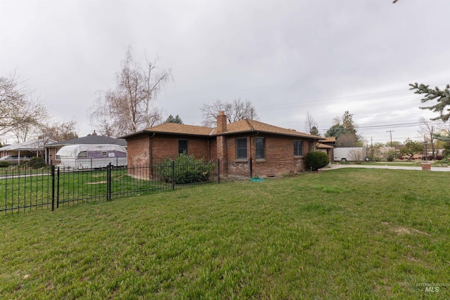 view of side of home with a lawn, a chimney, fence, brick siding, and driveway