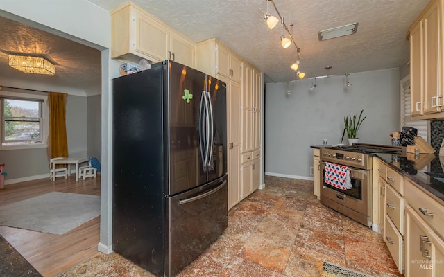 kitchen featuring baseboards, dark countertops, visible vents, stainless steel appliances, and light brown cabinetry