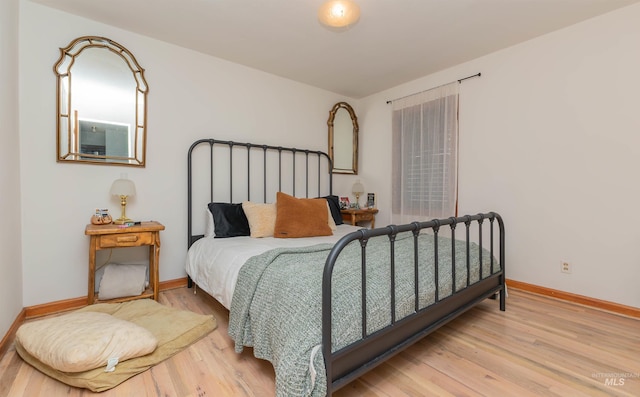 bedroom with wood finished floors and baseboards