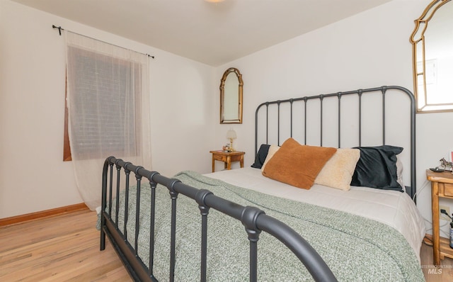 bedroom featuring light wood-style flooring and baseboards