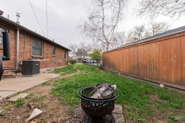 view of yard featuring central AC unit and fence