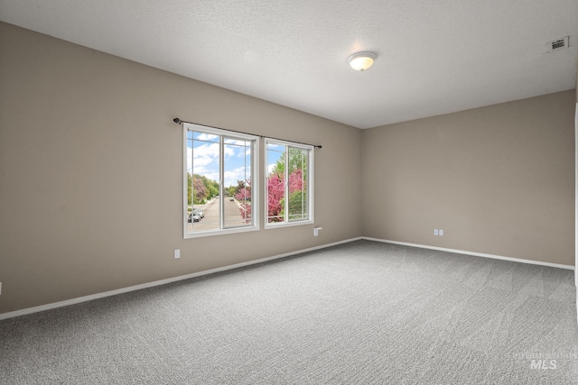 carpeted spare room featuring baseboards and visible vents