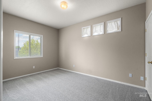 carpeted spare room with baseboards