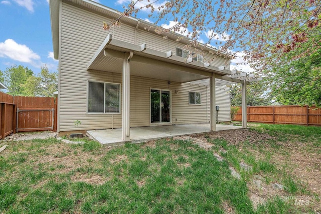 back of house featuring a fenced backyard, a yard, and a patio area