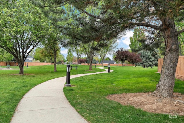 surrounding community with fence and a yard