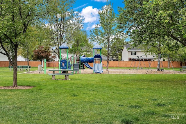 community jungle gym with a yard and fence