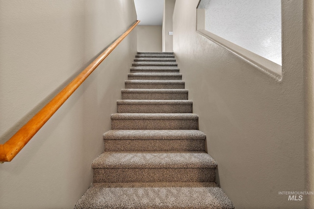 stairs featuring a textured wall