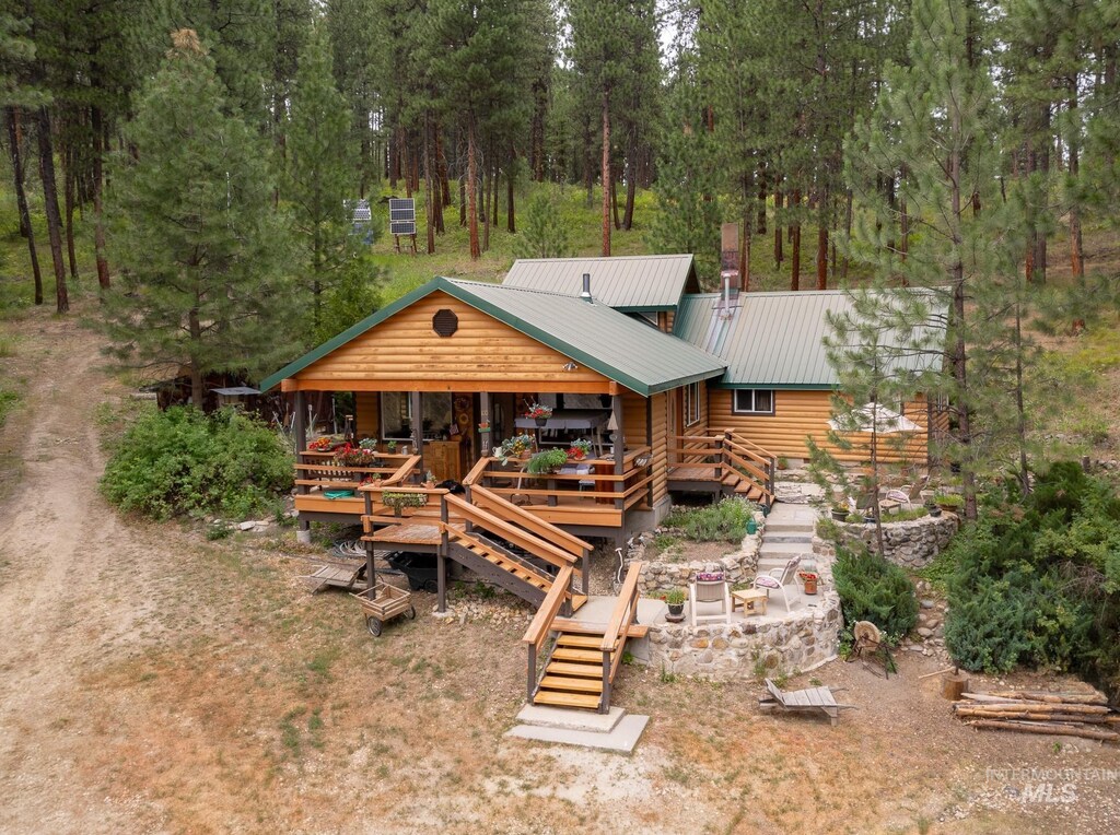 back of house with stairway and metal roof