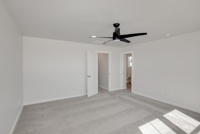 empty room with ceiling fan and light carpet