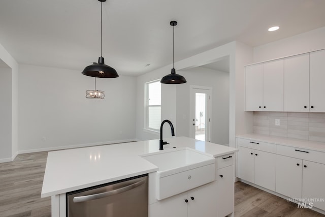 kitchen featuring sink, light hardwood / wood-style floors, stainless steel dishwasher, and an island with sink