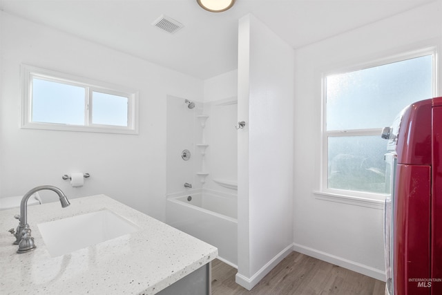 bathroom featuring bathing tub / shower combination, washer / dryer, hardwood / wood-style floors, and vanity