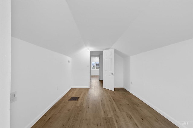 bonus room featuring lofted ceiling and light wood-type flooring