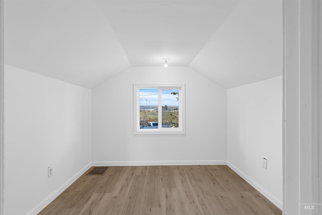 additional living space featuring lofted ceiling and light hardwood / wood-style floors