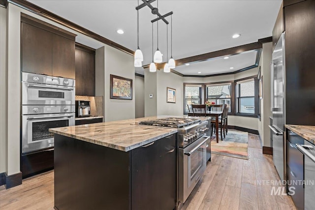 kitchen featuring dark brown cabinetry, crown molding, a kitchen island, and high end appliances