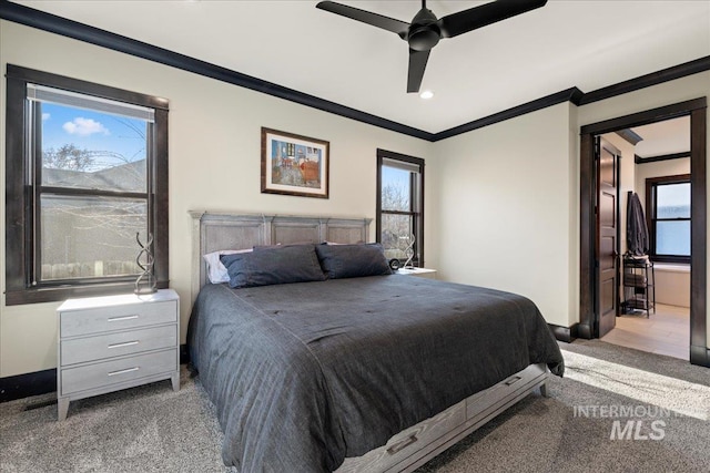 carpeted bedroom featuring ceiling fan, ornamental molding, and multiple windows