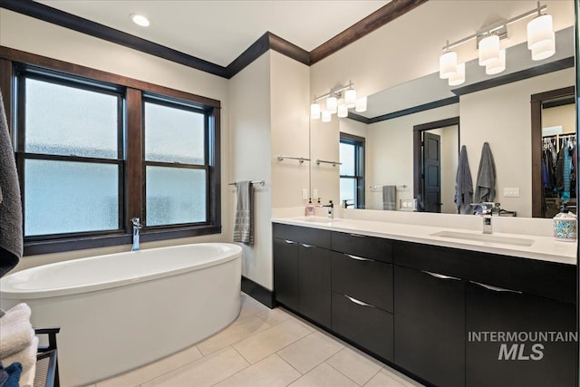 bathroom with a wealth of natural light, vanity, crown molding, and a bath