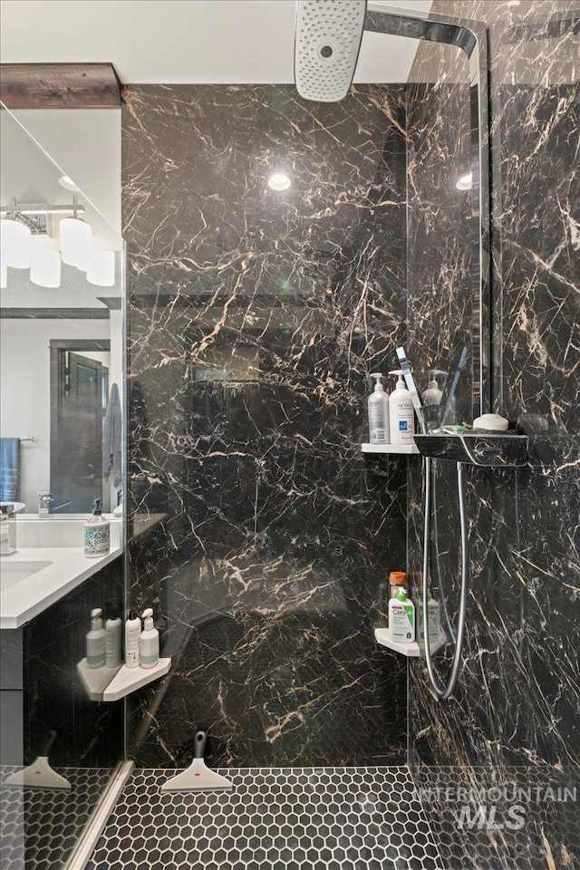 bathroom with walk in shower, vanity, and tile walls