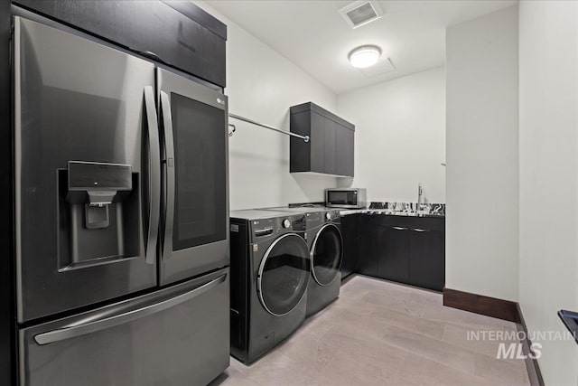 laundry area with cabinets, sink, and washing machine and clothes dryer