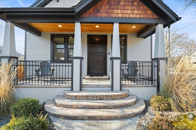 view of exterior entry featuring covered porch