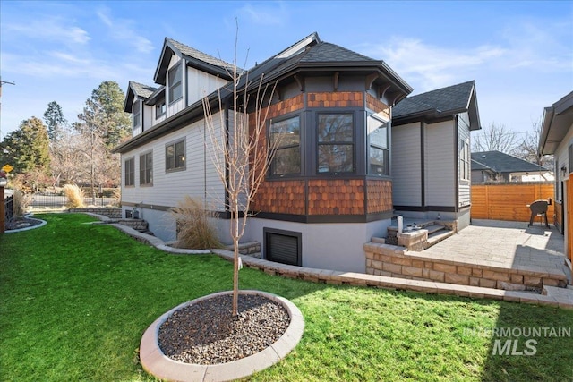 back of house with a patio area and a yard