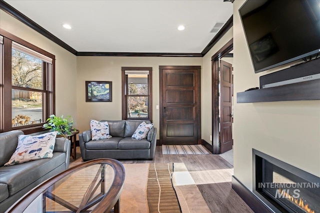 living room featuring a brick fireplace and ornamental molding