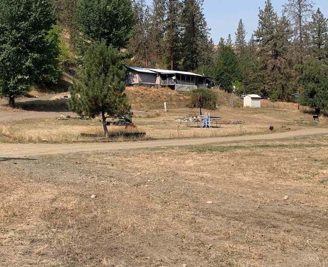 view of yard with a shed and a rural view