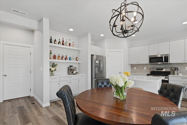 4953 W Apgar St, Meridian, ID 83646 - dining space with wood finished floors, a chandelier, and recessed lighting