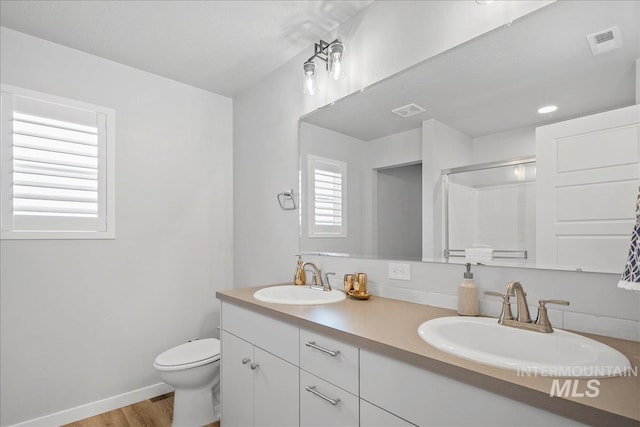4953 W Apgar St, Meridian, ID 83646 - bathroom with double vanity, an enclosed shower, toilet, wood finished floors, and baseboards