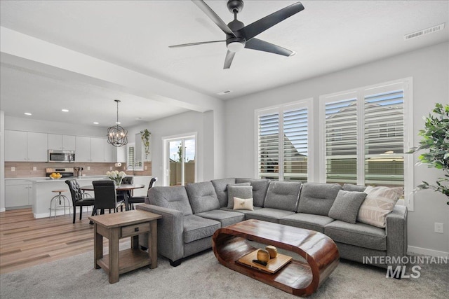 4953 W Apgar St, Meridian, ID 83646 - living area featuring a chandelier, a ceiling fan, recessed lighting, baseboards, and light colored carpet