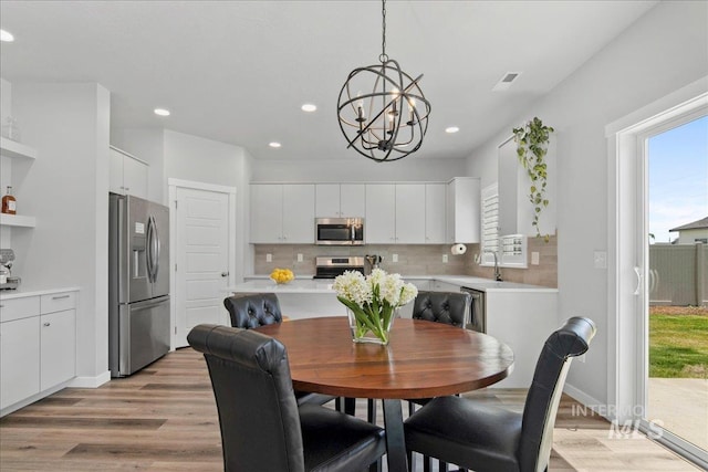 4953 W Apgar St, Meridian, ID 83646 - dining room featuring light wood-type flooring, healthy amount of natural light, a chandelier, and recessed lighting