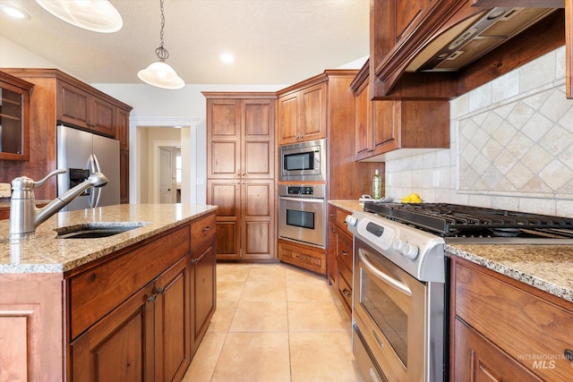 kitchen featuring glass insert cabinets, appliances with stainless steel finishes, brown cabinets, premium range hood, and a sink