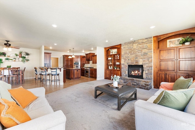 living room featuring baseboards, a stone fireplace, recessed lighting, and built in features